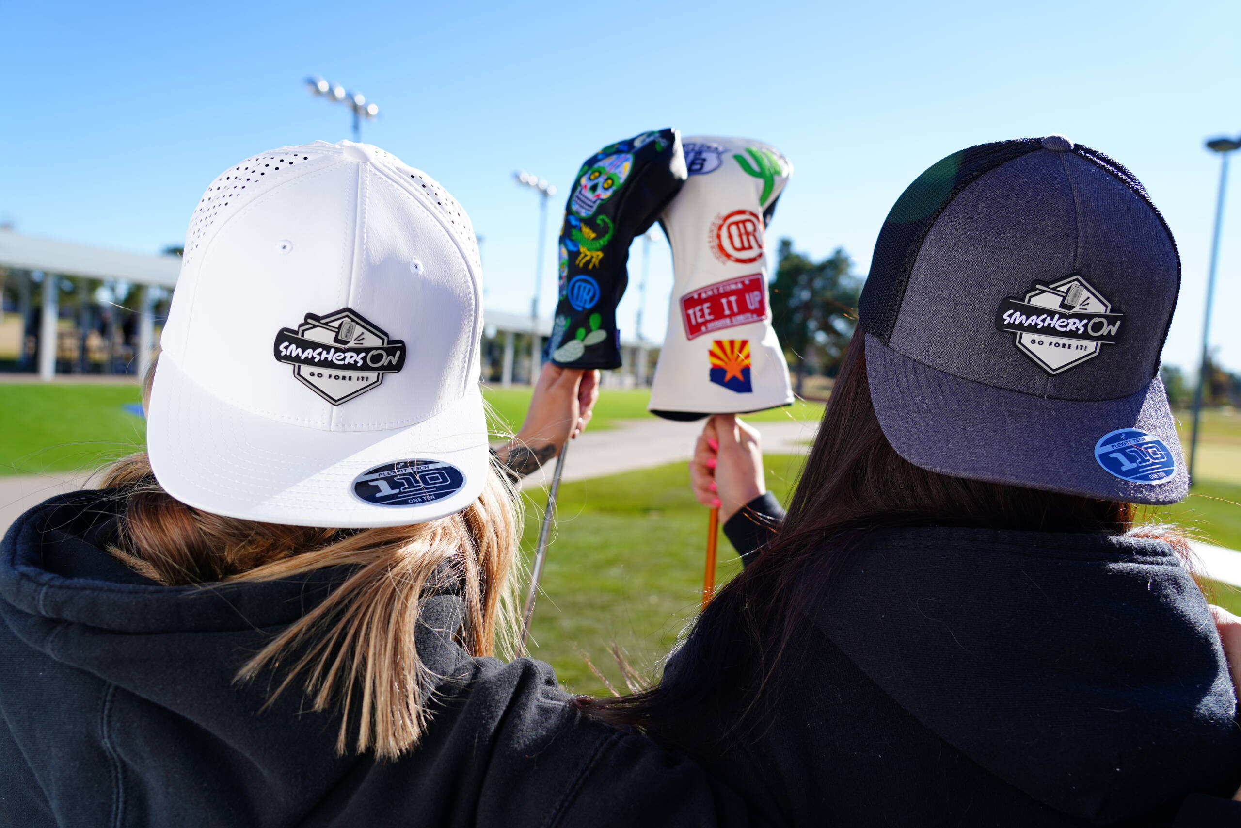 Two golf gals holding clubs